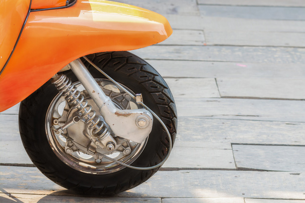 Moto de rueda delantera sobre suelo de madera
 - Foto, imagen