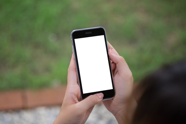 Close up de uma mulher usando telefone inteligente com celular em branco e xícara de café. Telefone inteligente com tela em branco e pode ser adicionar seus textos ou outros no telefone inteligente
. - Foto, Imagem