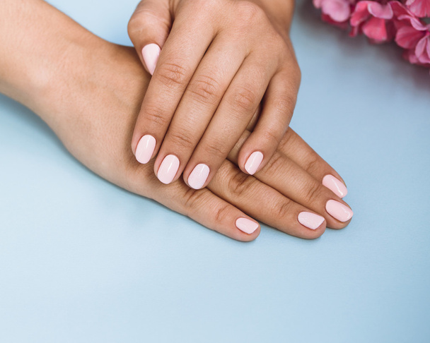 Mooie vrouw met mooie roze manicure nagels - Foto, afbeelding