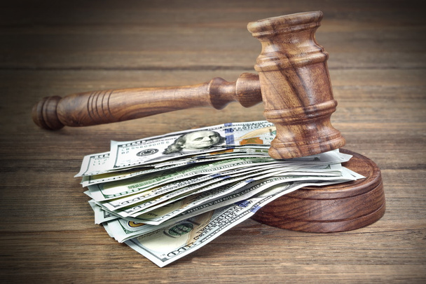Δικαστές ή Auctioneers σφυρί ή σφυρί και μεγάλα χρήματα στοίβα σε ξύλινο πάγκο ή ξύλινο τραπέζι φόντο, ιδέα για το οικονομικό έγκλημα, κοντινό πλάνο - Φωτογραφία, εικόνα