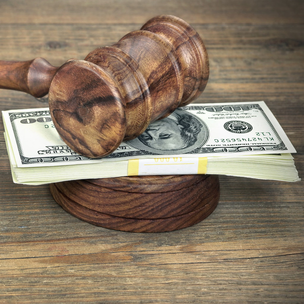 Jueces o subastador martillo y dólares en efectivo en mesa de madera
 - Foto, imagen
