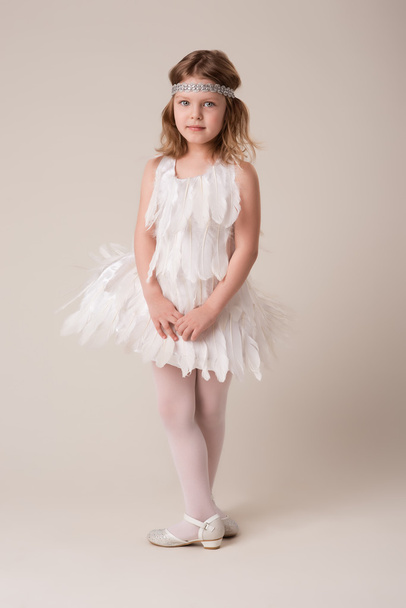  Porträt eines schönen, fröhlichen Mädchens in einem Kleid aus weißen Federn - Foto, Bild