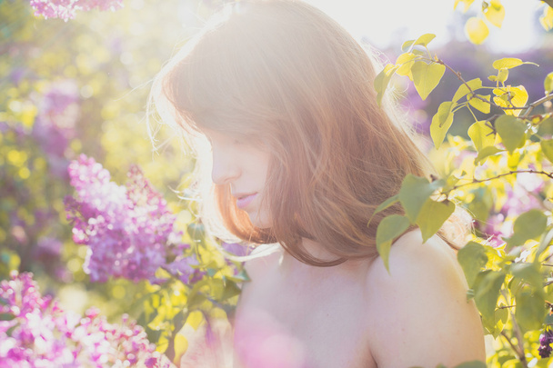 Adorable red-haired girl in spring blossoming garden.  - Photo, Image