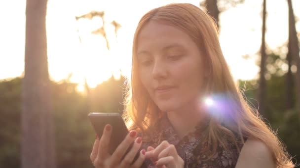Rusovlasá mladá dívka pomocí mobilního telefonu - Záběry, video