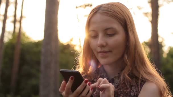 Chica joven pelirroja usando el teléfono celular
 - Metraje, vídeo