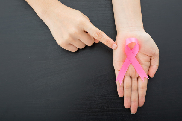 female hands holding pink ribbon, breast cancer concept - Photo, Image