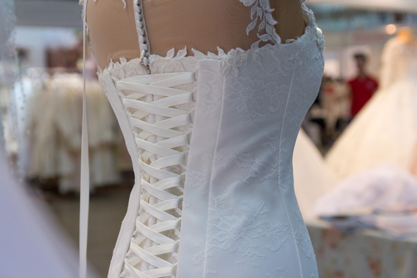 Beautiful wedding dress hanging in a store - Valokuva, kuva