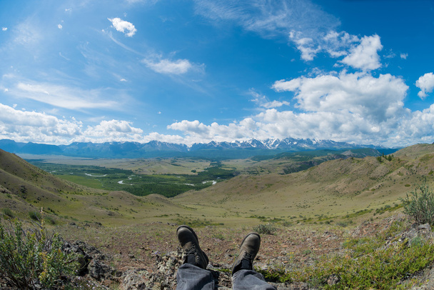 feet in the shoes against the backdrop of the mountains - Photo, image