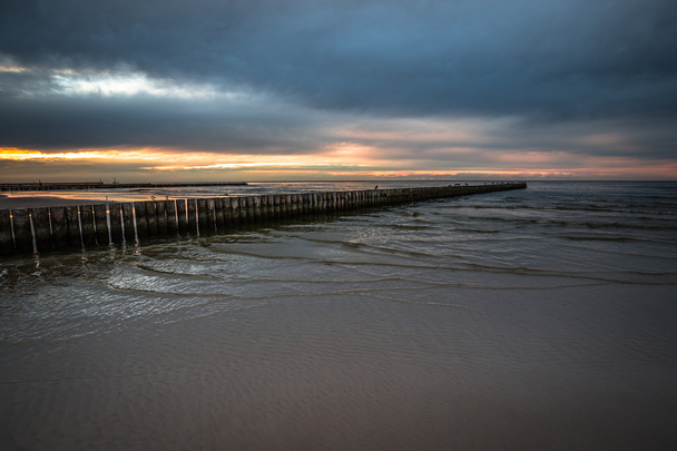 Naplemente, a strand egy fából készült móló Leba, Balti-tenger, Po - Fotó, kép