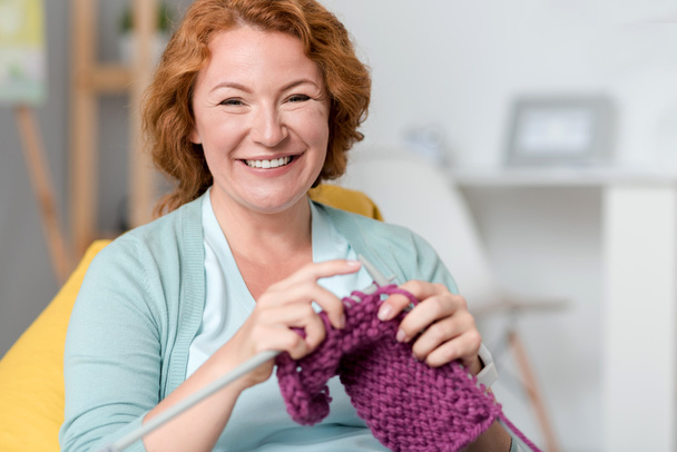 Cheerful smiling woman knitting - Fotografie, Obrázek