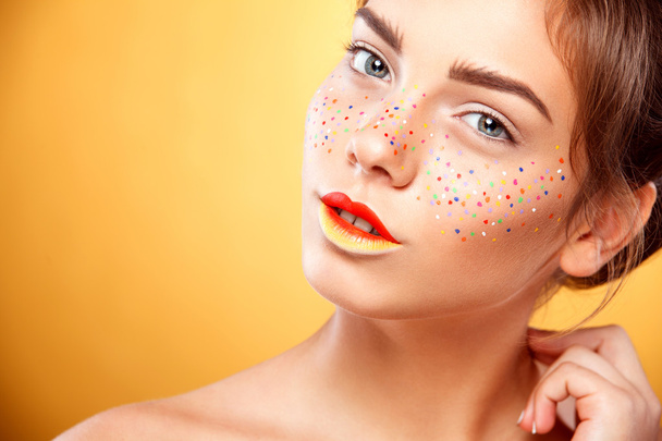 Portrait of bright beautiful girl with art colorful freckles make-up - 写真・画像