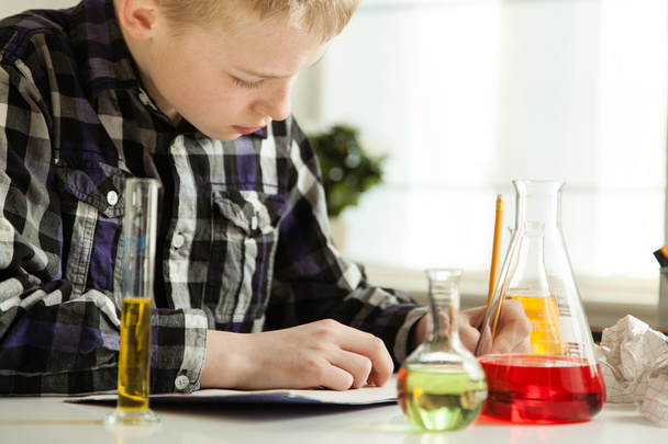 Ijverige jonge jongen doet zijn wetenschappelijk huiswerk - Foto, afbeelding
