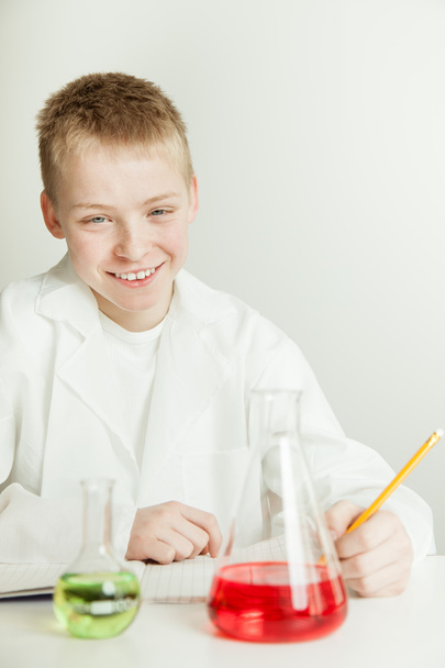 Científico sonriente con cuaderno y vasos de precipitados
 - Foto, Imagen