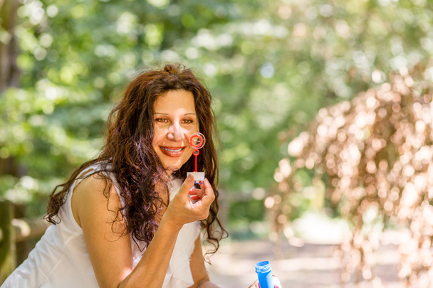 adult woman blowing soap bubbles - Foto, Bild