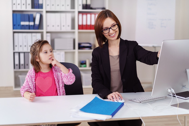 Young businesswoman amusing her small daughter - Foto, afbeelding