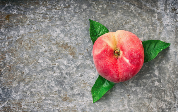 one flat peach with leaves  - Foto, immagini