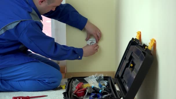 Εργαζόμενος ηλεκτρολόγο επιδιορθώσετε μια ηλεκτρική πρίζα σε διαμέρισμα - Πλάνα, βίντεο