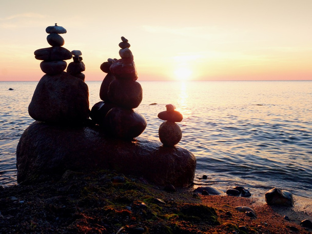 Balanced stone pyramid on sea shore, romantic sunset at horizon - Photo, Image