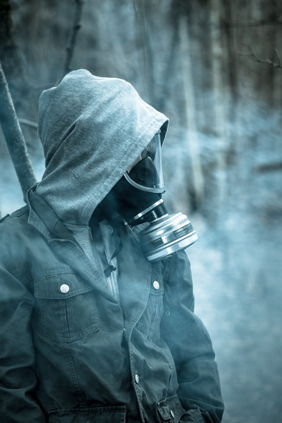 Tiener met capuchon jas en gasmasker - Foto, afbeelding