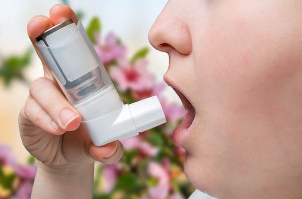 Астматическая женщина страдает астмой и держит ингалятор в руке.
. - Фото, изображение