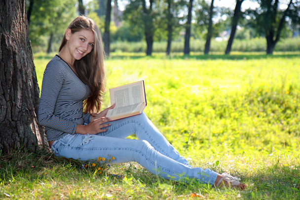 Girl with a book in the park - Photo, Image