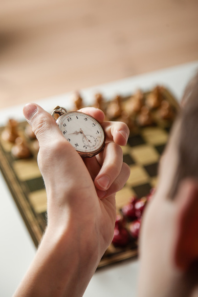 Person Holding Stop Watch Above Chess Board - Foto, Bild