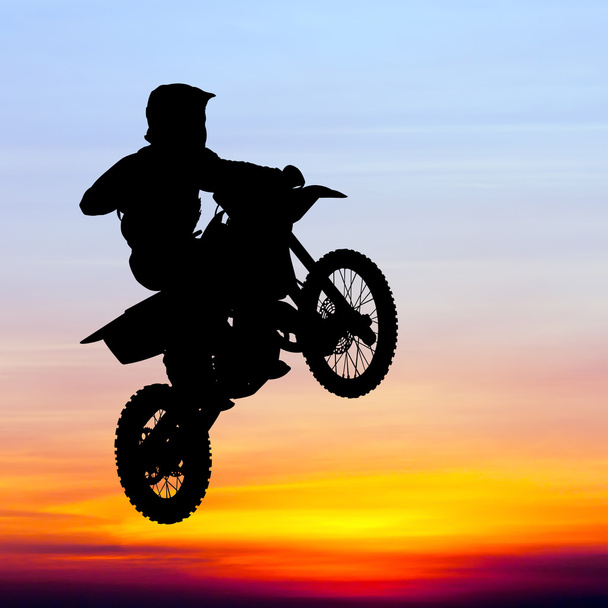 silueta de motocross rider saltar en el cielo al atardecer
 - Foto, Imagen