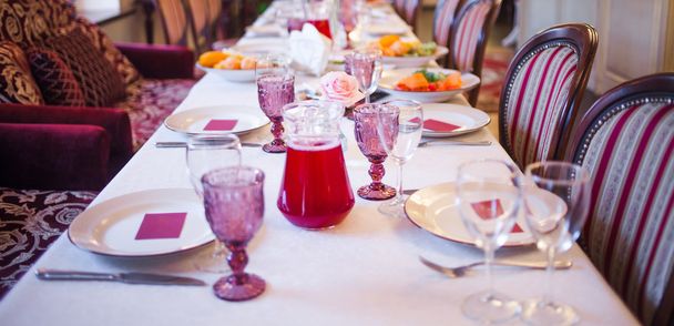 Interior del restaurante, mesa grande para banquete, decorada en tonos borgoña
 - Foto, imagen