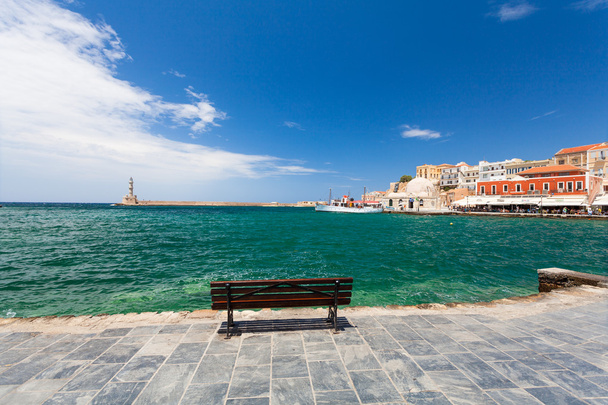 Chania, Crete - June 26, 2016: Empty bench on the embankment the Old Town of Chania and Lighthouse, Crete. - Фото, зображення