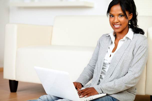Relaxed young woman smiling at you with a laptop - Foto, Imagen