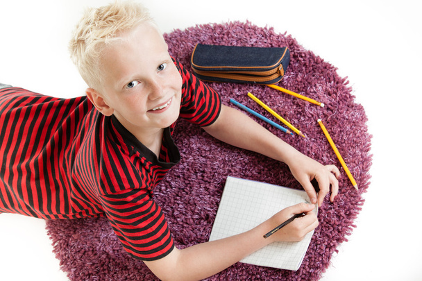 Счастливый мальчик работает над своим домашним заданием
 - Фото, изображение