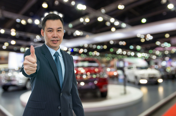 Πωλητής ευτυχισμένη αυτοκινήτων στο auto show  - Φωτογραφία, εικόνα