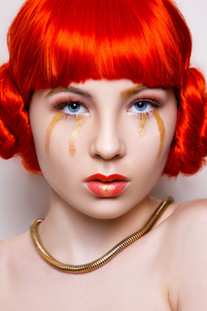 Woman in red and gold fashion make up and red hair on white background in studio photo. Art beauty photo - Foto, Imagen