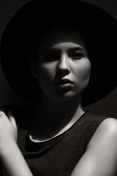 High fashion look.glamor closeup portrait of beautiful stylish Caucasian young woman model with perfect clean skin in big black hat. Black and white photo - Photo, Image