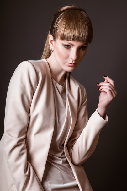 beautiful woman model posing in simple elegant in a light suit in the studio on black background - Fotoğraf, Görsel