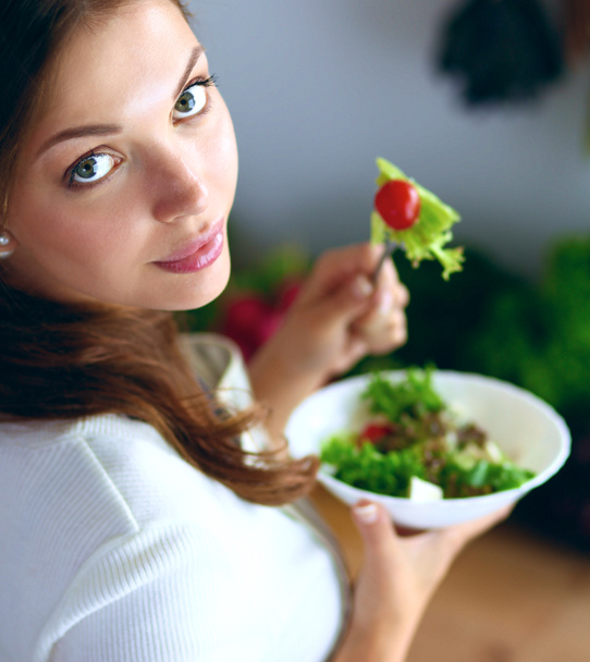 Young woman eating salad and holding a mixed salad - Photo, Image
