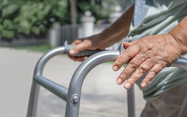 Mujer mayor usando un andador de la calle cruzada
 - Foto, Imagen