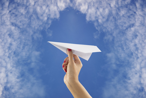 Ruka držící papírové letadlo na obloze na pozadí - Fotografie, Obrázek