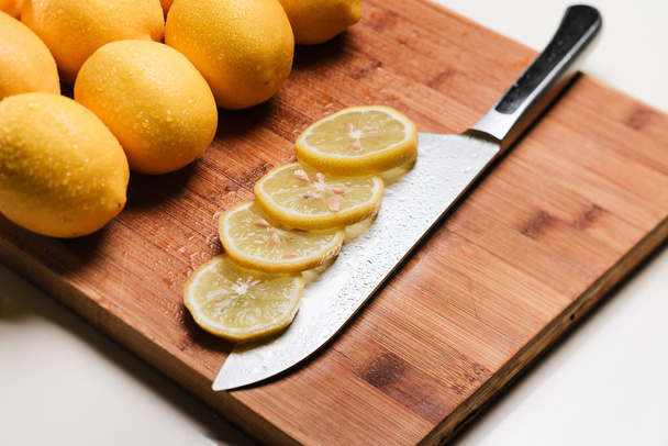 Slices of lemon on a knife. Isolated - Φωτογραφία, εικόνα