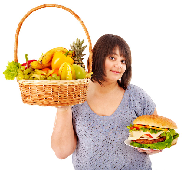 Жінка вибирає між фруктами та гамбургером
. - Фото, зображення