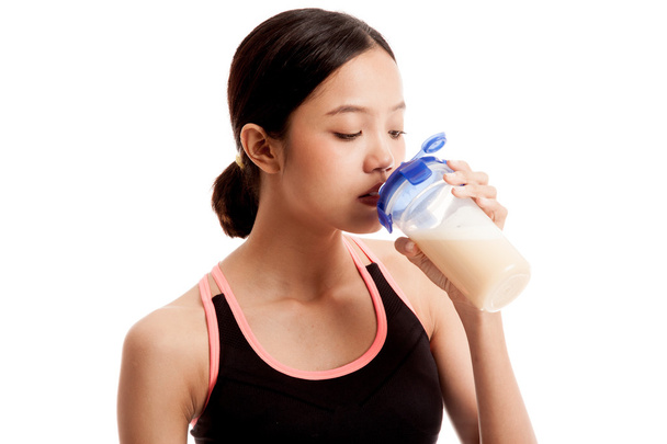 Beautiful Asian healthy girl drinking whey protein - Photo, image