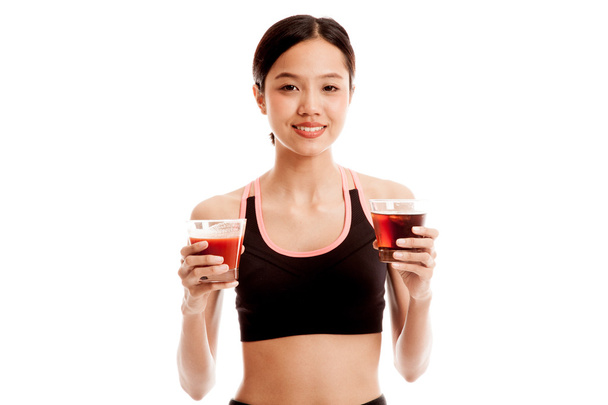 Belle fille asiatique en bonne santé avec du jus de tomate et des boissons au cola
 - Photo, image