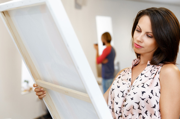 Jovem caucasiano mulher de pé na galeria de arte frente de pinturas
 - Foto, Imagem