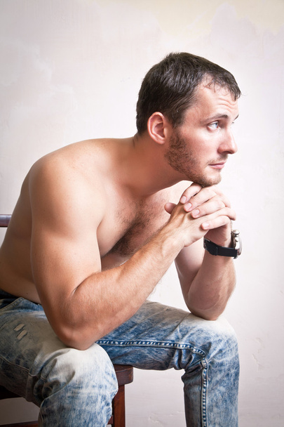 Portrait of thoughtful attractive man sitting on a chair - Photo, Image