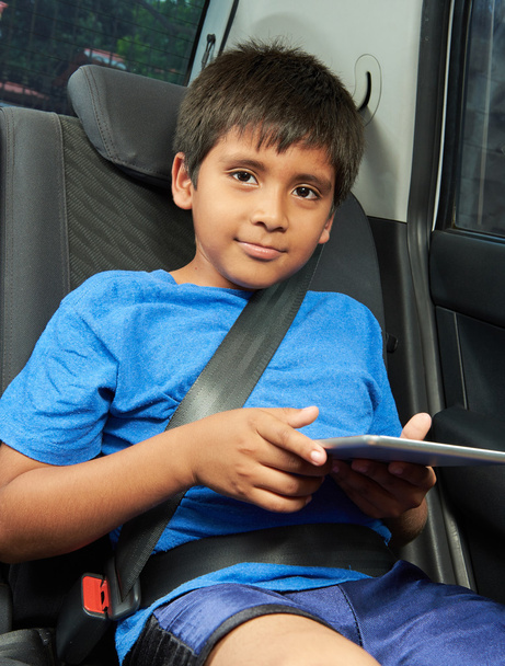 jongen met tablet achterkant van auto - Foto, afbeelding