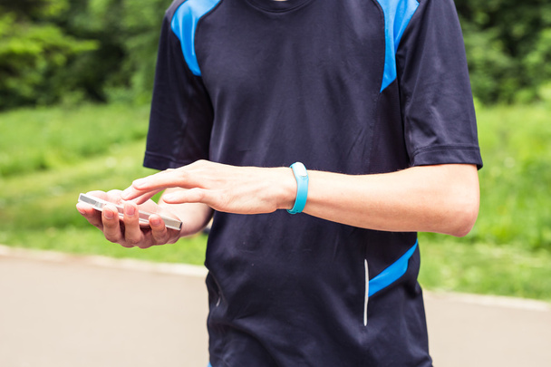 Hand wearing a fitness tracking armband - Photo, Image