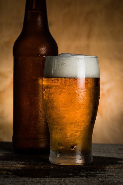 Beer in bottle and glass with ice drops - Photo, image