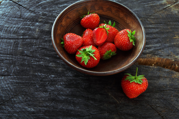 Červené čerstvé jahody na černém rustikální dřevěné pozadí - Fotografie, Obrázek