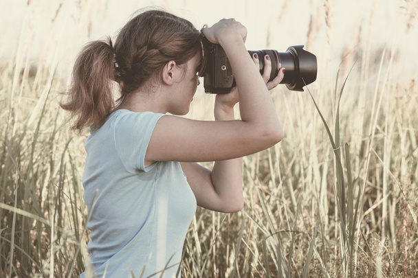 Vintage portrait of a young girl photographer working in the field of professional photographic equipment - Fotó, kép