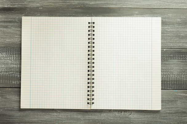 checked notebook on wooden table - Φωτογραφία, εικόνα